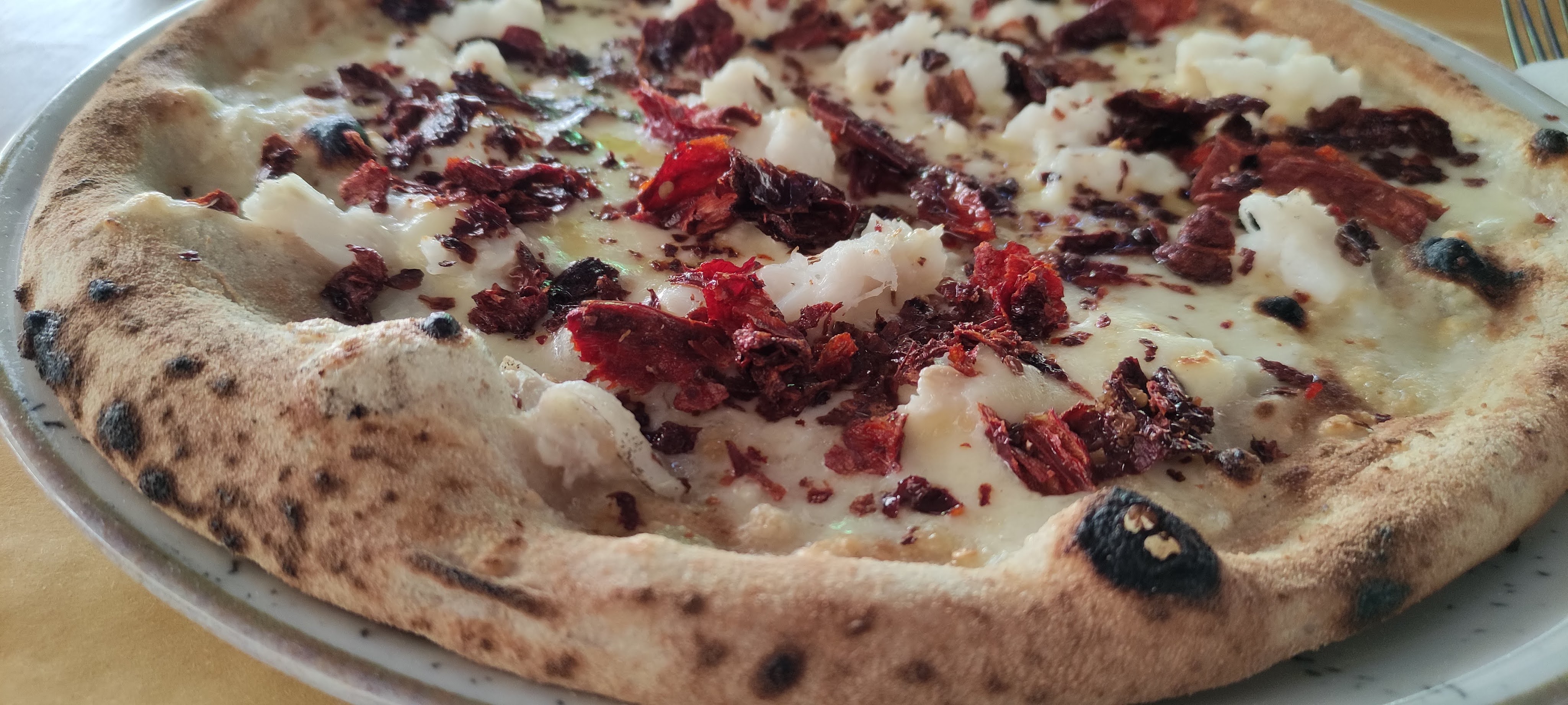 pizza con farine integrali, fiordilatte, peperone crusco, baccalò, olio EVO